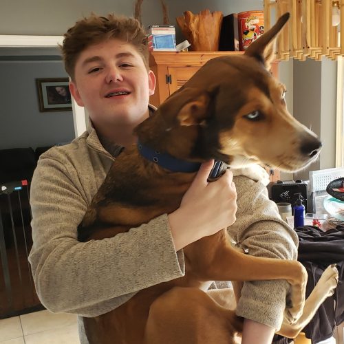 Young Man Holding A Large Dog